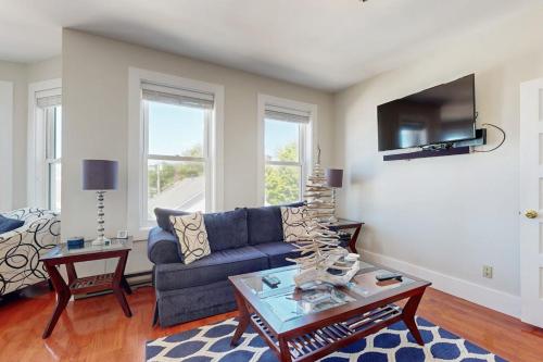 a living room with a blue couch and a table at Admiral's Quarters in Boothbay Harbor