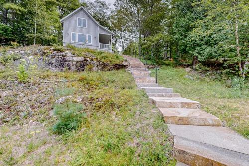 a set of stone steps leading up to a house at Periwinkle Cottage | Sunny cottage in Westport Island overlooking the river in Westport