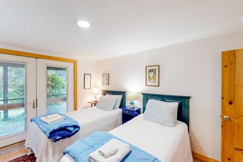 a bedroom with two beds and a window at Dog-friendly 3-story home with wood stove, deck, grill, ocean views, W/D, AC in Southwest Harbor