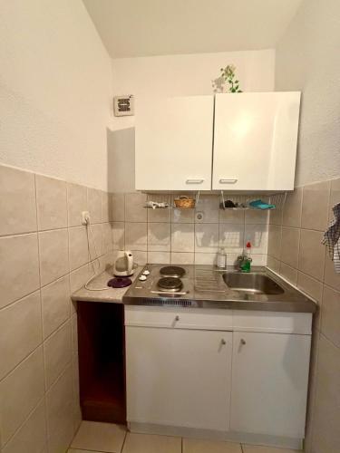 a small kitchen with white cabinets and a sink at Studio Apartments Ivo in Baška Voda