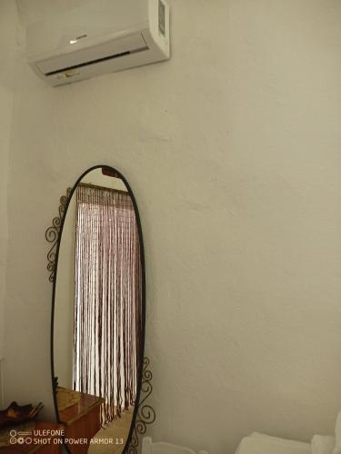 a mirror on a wall with a air conditioner at ''RENATA'' Studio in Kithnos