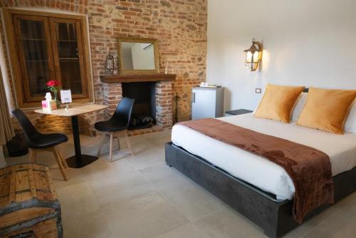a bedroom with a bed and a table and a fireplace at Cascina Bella - Piozzo in Piozzo