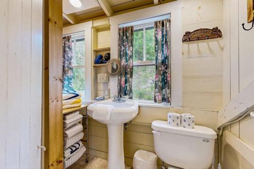 a bathroom with a sink and a toilet and a window at Bayfront cottage with fantastic views & minutes to downtown - Dog-friendly in Boothbay Harbor