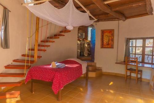 a dining room with a table and a staircase at Tsarasoa Lodge in Ambalavao