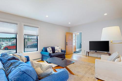 a living room with a blue couch and a tv at Waterfront, walkable home with beautiful kitchen & washer/dryer - dog-friendly in Camden