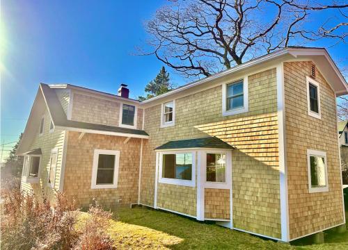 a brick house with white windows and a roof at Ocean Point Colony Home w/ Sunroom & Sweeping Ocean Views, Dog-friendly in East Boothbay