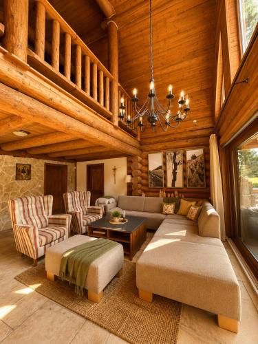 a living room with a couch and chairs and a chandelier at Chalet Velora in Oščadnica