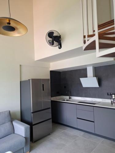 a kitchen with a stainless steel refrigerator and a couch at Apartamentos Zenit Mar in Noja
