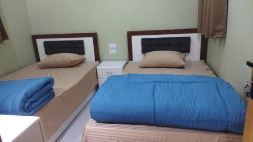 a bedroom with two beds with blue sheets at Carmine Studio Dahab in Dahab