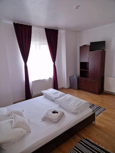 a white bed in a room with a large window at Casa Flavius in Văliug