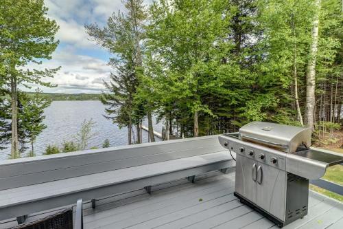a barbecue on a deck with a view of a lake at Lakefront Chalet-Style Home with Large Deck, a Dock & Beautiful Lake Views in Greenville