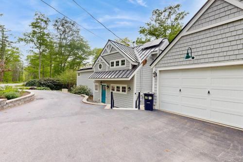 ein weißes Haus mit Garage und Einfahrt in der Unterkunft Stunning riverfront home, hot tub, BBQ, and washer & dryer in Edgecomb