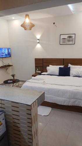 a bedroom with two beds and a table in it at PaoLia Meublé 3 in Cotonou
