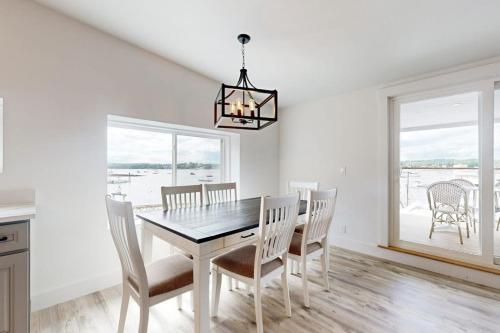 a dining room with a table and chairs and a window at Elegant Oceanfront Condo with Stunning Harbor Views & Spectacular Sunsets in Boothbay Harbor