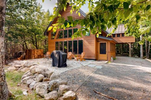 a log home with a patio in front of it at The Cabin on 32 wooded acres - tranquil new-build with sauna & forested views in Franklin