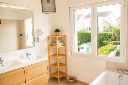 a bathroom with a sink and a window at Le Forest - Saint-Cyr-l'École in Saint-Cyr-lʼÉcole