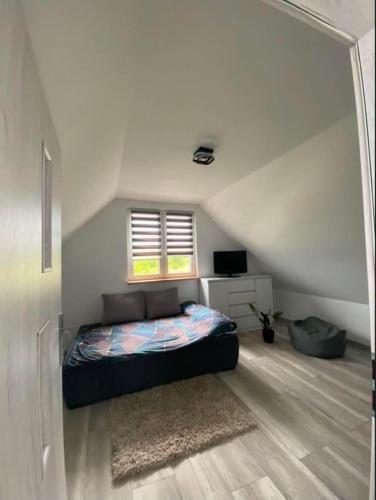 a bedroom with a bed in the middle of a room at Wakacyjne relaksacyjnie in Szczytno