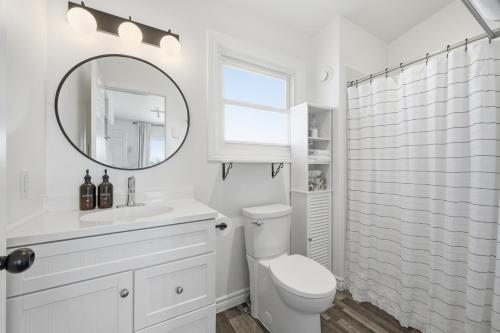 a white bathroom with a toilet and a mirror at The Birch in Wellington