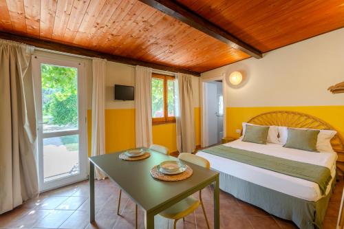 a bedroom with a bed and a table in a room at L'Agrumeto domos in Teulada