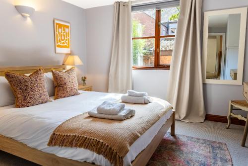 a bedroom with a bed with two towels on it at Spacious One-Bed Apartment in Chester in Chester