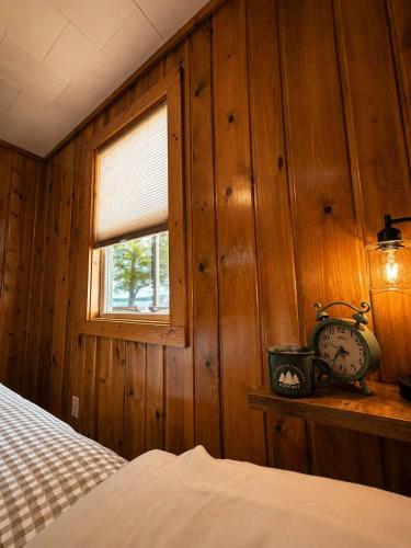 a bedroom with a bed and a window and a clock at A Shore Thing: Beach Access in Saint Germain
