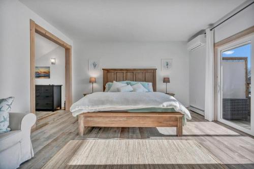 a white bedroom with a bed and a couch at Ocean Breeze West Wind – Updated 2BR/2BA home step in Owls Head