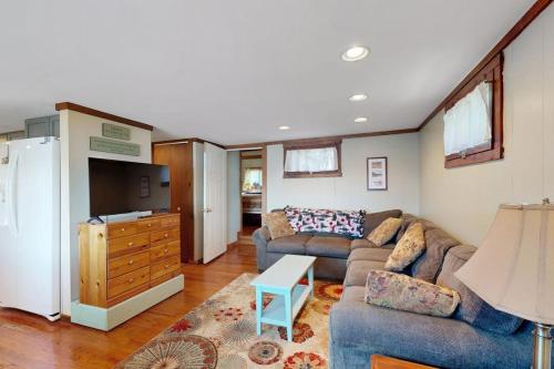 a living room with a couch and a refrigerator at Secluded lakefront cottage great views, dock & boat launch in Ellsworth
