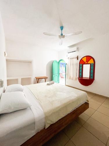 a bedroom with a bed and two stained glass windows at Aruma Stays in Brisas de Zicatela