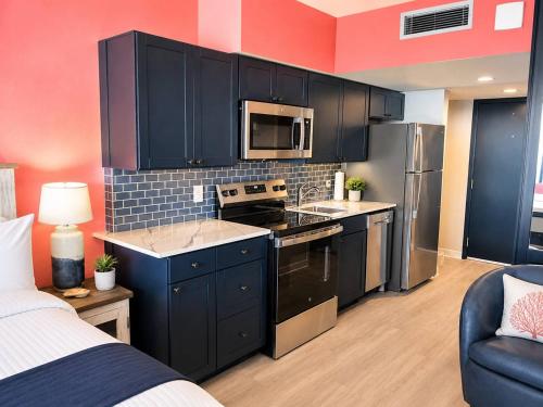 a kitchen with black cabinets and a stove top oven at Updated Oceanfront Suite by Skywheel Yachtsman 902 in Myrtle Beach