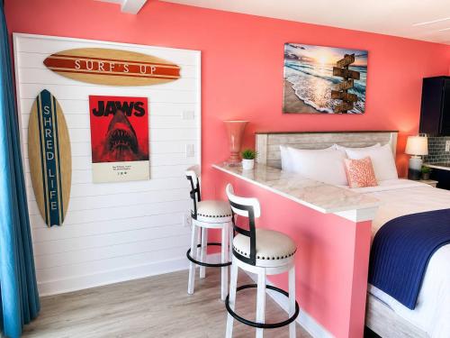 a bedroom with a bed and a desk with two chairs at Updated Oceanfront Suite by Skywheel Yachtsman 902 in Myrtle Beach
