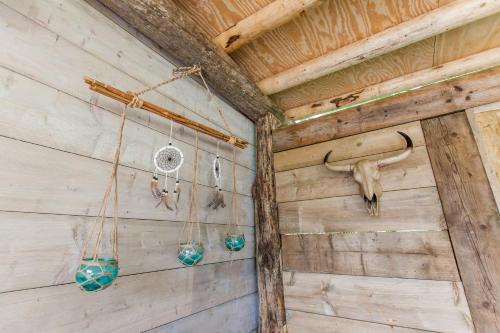 a barn room with wooden walls and hanging items at Ibiza Summer Lodge in Brouwershaven