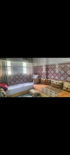 a room with several couches and a curtain at Maison Bab boujloud in Fez
