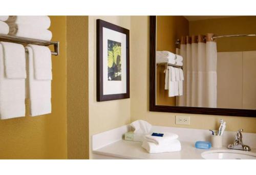 a bathroom with a sink and a mirror and towels at Motel 6 Fairfield OH Cincinnati in Fairfield