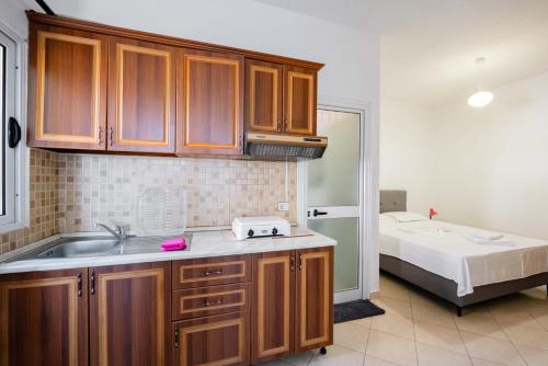 a kitchen with a sink and a bed in a room at Nefeli apartments in Borsh