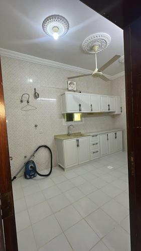 a kitchen with a ceiling fan and a tile floor at رابغ in Rabigh