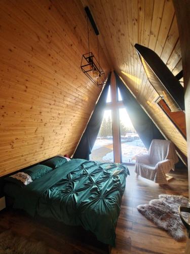 a bed in a room with a wooden ceiling at Cabana Golden Sunset in Mărişel
