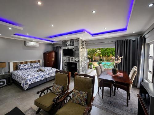a bedroom with a bed and a table and chairs at Waterfall City Guest Lodge in Sandton