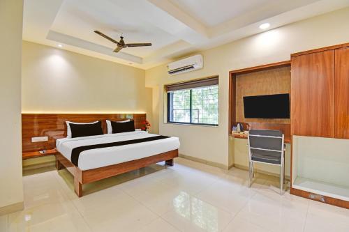 a bedroom with a bed and a flat screen tv at Hotel O RVC GRAND CENTRAL in Viman Nagar
