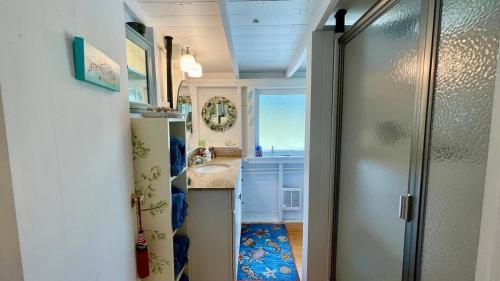 a small bathroom with a sink and a shower at Whispering Spruces; Cozy Studio with Queen Bed & W in South Thomaston