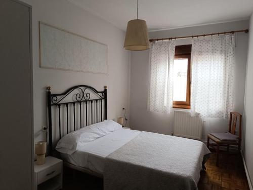 a bedroom with a white bed and a window at Casa Montse - Derecha in Colombres