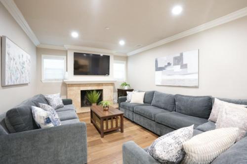 a living room with two couches and a fireplace at Lavish 5 Bedroom, 4 Bath Pool Home 3/4 Mile To Disney in Anaheim