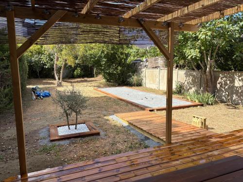 a backyard with a wooden pergola and a tree at CAEN ça repose ! in Caen