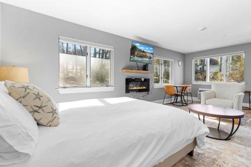 a bedroom with a large white bed and a living room at Mabel's Maine Studio on the River in Edgecomb