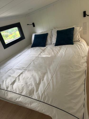 a large white bed in a room with a window at Kniveton Wood Hut in Ashbourne