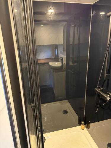 a shower with a glass door in a bathroom at Kniveton Wood Hut in Ashbourne