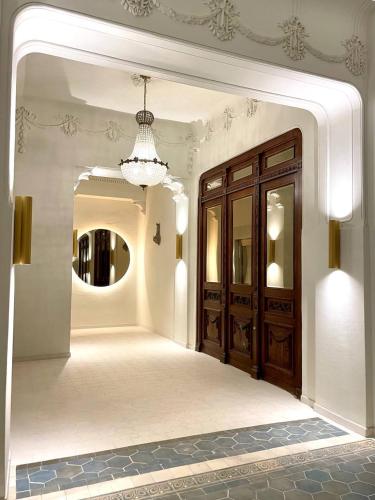 a hallway with a large wooden door and a mirror at The Gediminas Residence in Vilnius