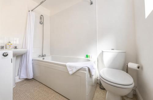 a white bathroom with a toilet and a bath tub at York House - Garston - 3 bedroom - Sleeps 6 in Liverpool