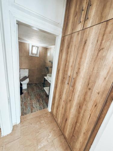 a bathroom with a wooden door in a room with a toilet at Hotel Galini Polychrono in Polychrono