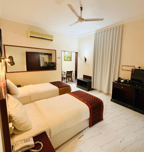 a hotel room with two beds and a television at Al Barka Palace Hotel in Ma‘ābīlah