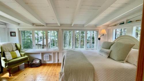 a large room with a bed and chairs and windows at Whispering Spruces; Cozy Studio with Queen Bed & W in South Thomaston